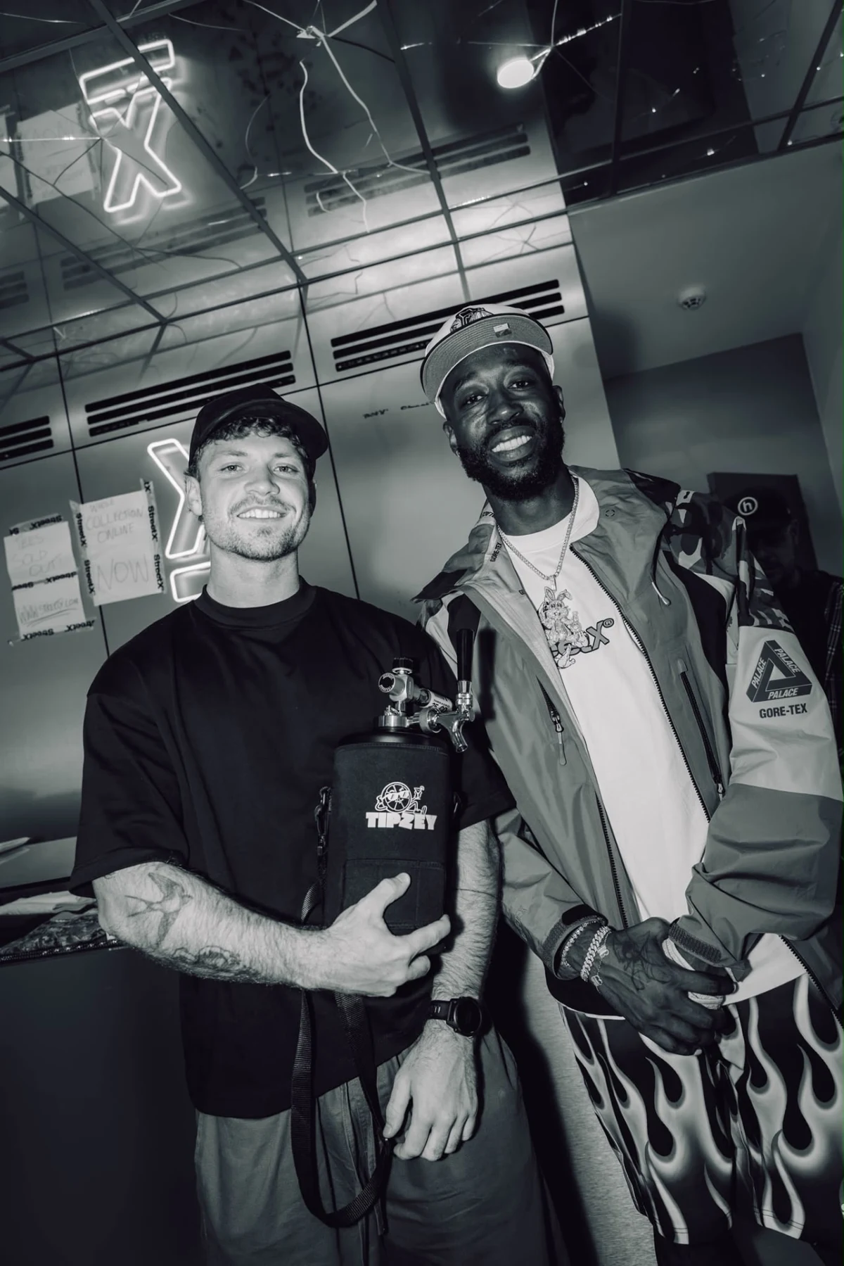 Two friends smiling with a black Tipzey mini keg